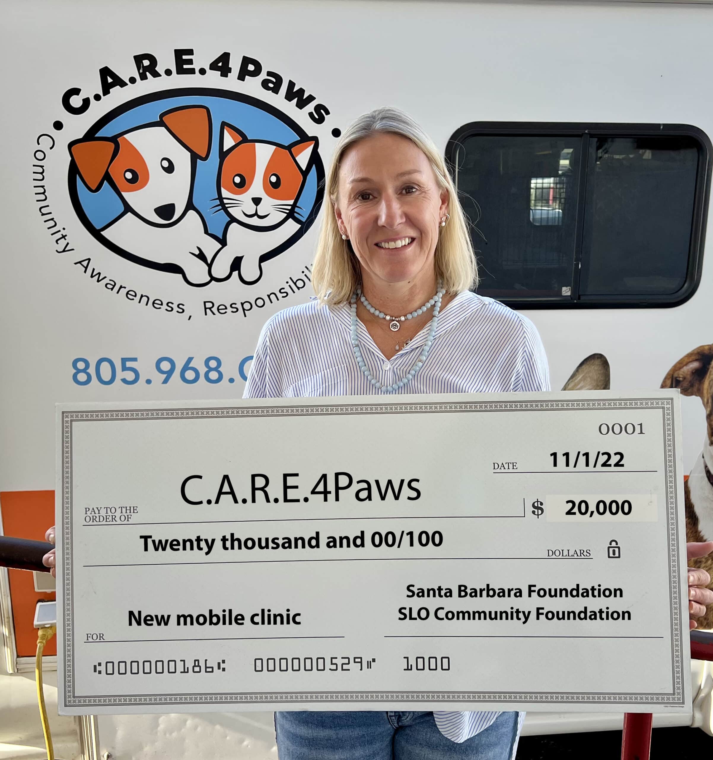 C.A.R.E.4Paws Executive Director holding large donation check