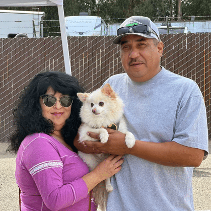 Man and woman holding small dog at a vaccine clinic
