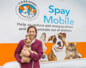 Man with dog in front of C.A.R.E.4Paws Mobile Pet Wellness Clinic