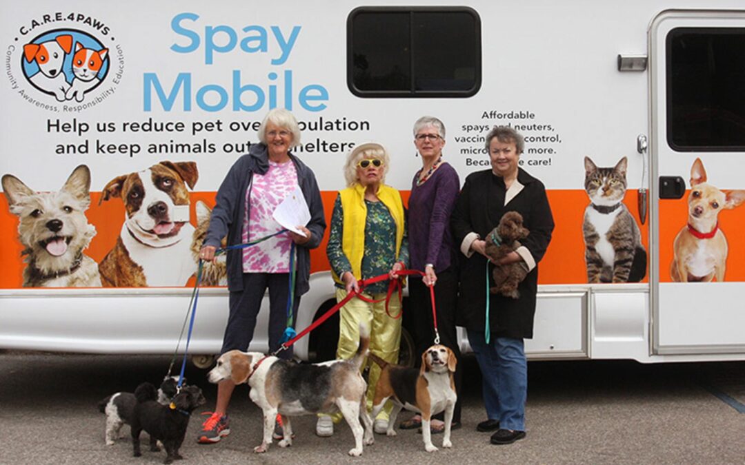 Happy pet owners in front of the C.A.R.E.4Paws Mobile Clinic