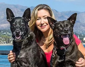 Wendy Domanski, C.A.R.E.4Paws Community Programs Coordinator with two large black dogs
