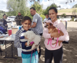 A family with their two dogs at a C.A.R.E.4Paws Mobile Pet Clinic